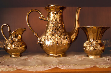 An old vintage golden tea set on wooden background