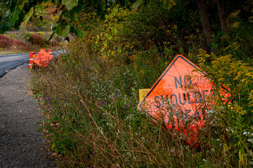 A road warning sign is put a little too far off the shoulder of this road in Upstate NY in the town...