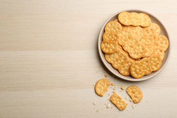 Delicious crispy crackers on wooden table, flat lay. Space for text