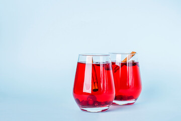 Christmas mulled red wine with spices on blue background. Cranberry drink with cinnamon and anise. Minimalism, copy space for text