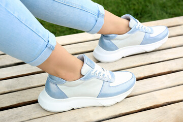 Woman wearing comfortable stylish sneakers outdoors, closeup