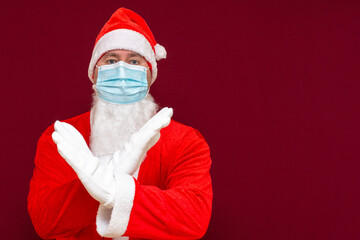 Closeup santa claus costume rejection expression crossing arms and palms doing negative sign,wears medical mask