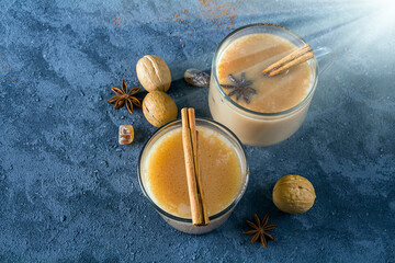 Glass cup of traditional indian masala tea on dark background. Winter hot drink cocoa with cinnamon. Copy space for text