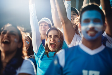 Argentinian soccer fans cheering in stadium - obrazy, fototapety, plakaty