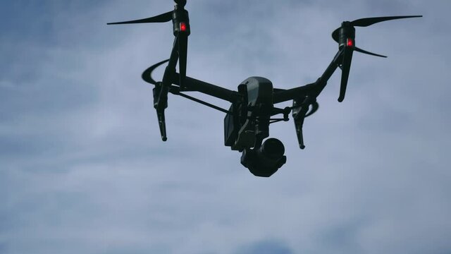 DJI Inspire drone with professional camera take off and fly in mountain environment. Editorial video.
