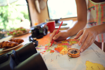 Young traveler with world map planning trip in motorhome, closeup