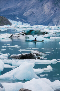 A sea kayaker paddling through ice in the lagoon at the terminus of the McBride Glacier. 