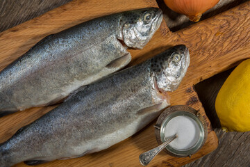 Fish, fresh trout on a cutting board, and the old wooden background