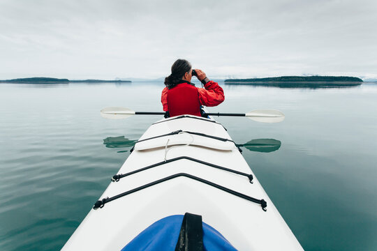 Sea kayakers looking at nautical chart and map,an inlet on the Alaska coastline. 