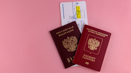 two passports with a plane ticket on the rose background
