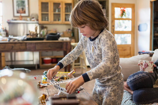 4 year old boy wearing pajamas playing with toys at home