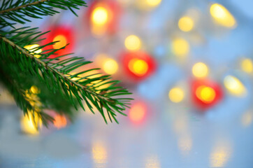 branch of a Christmas tree on a background of Christmas lights new year background, no focus, blur, blurry Closeup of Christmas tree background