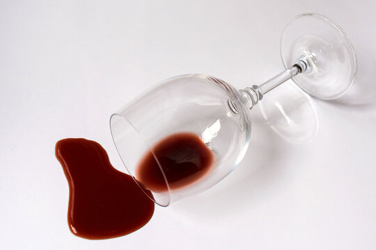 
Glass with spilled red wine on a white background.
Copy space.