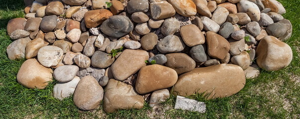 Pile of stones on the grass in summer
