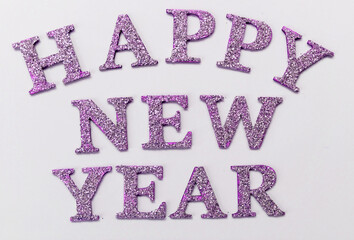 
Inscription Happy New Year in shiny pink letters on a white background.
