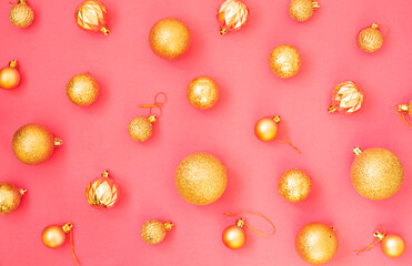 Fototapeta na wymiar Gold glitter. Christmas balls of different sizes on a pink background pattern. Flat lay, top view