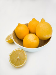 View on two lemons, one full and one cut in half. Yellow, colorful and juicy fruits on white background.