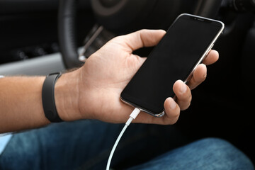 Man charging smartphone in car, closeup view