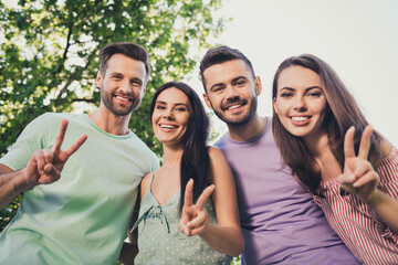 Low angle view photo of beautiful women handsome men make v-sign happy positive photo free time outside in park outdoors