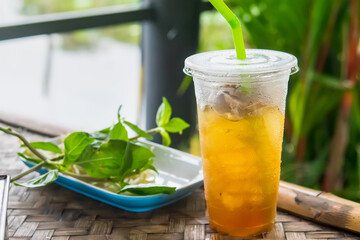 close up of ice cold Longan fruit juice in glass with straw on old table