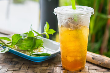 close up of ice cold Longan fruit juice in glass with straw on old table