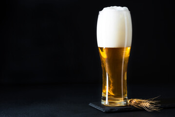 Glass of beer on dark concrete background. Copy space