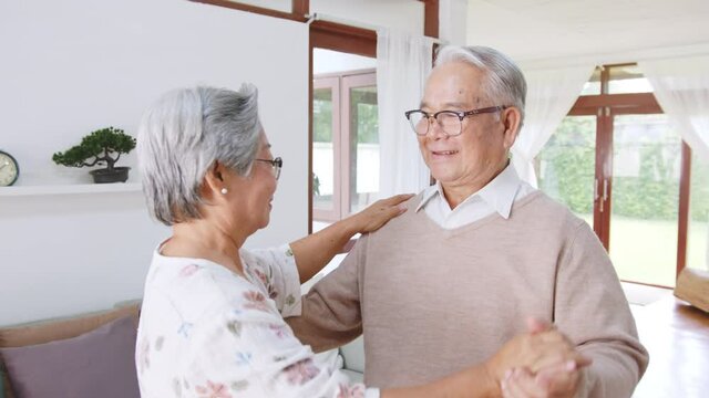 Asian senior couple enjoy dancing to relax at home, senior retirement lifestyle concept