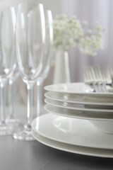 Stacked plates on light grey table, closeup