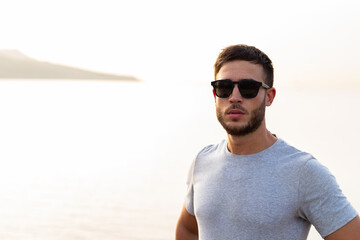 Young athlete man looking at camera outdoor with sunglasses