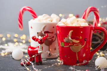 Christmas hot chocolate with marshmallow and sweet cane on gray concrete table. Traditional hot drink at Christmas. Soft focus