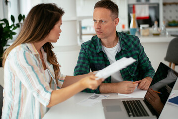 Obraz premium Husband and wife preparing bills to pay. Young couple using laptop..