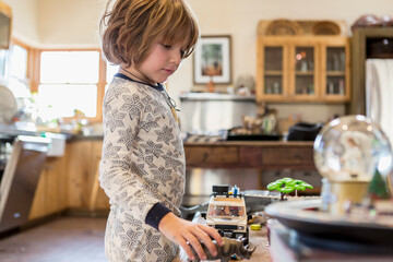 4 year old boy wearing pajamas playing with toys at home