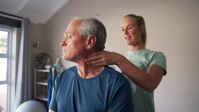 Shot of a young female physiotherapist manipulating the neck of a senior man in clinic