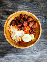 Wok rice cooked with soy sauce, vegetables and chicken pieces.