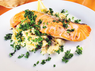 Grilled salmon with sauce, lemon and tomato