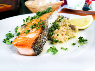 Grilled salmon with sauce, lemon and tomato