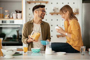 Young couple eating breakfast at home. Loving couple enjoying in the kitchen