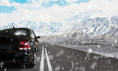 the car goes along the winter lake. rear view. snowy mountain peaks