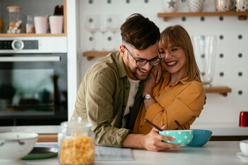 Young couple eating breakfast at home. Loving couple enjoying in the kitchen