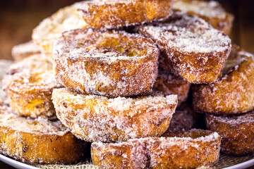 fried or baked bread with cinnamon and sugar in an antique copper skimmer. Called rabanada in brazil, portuguese gold slice in portugal and spanish torrijas in spain