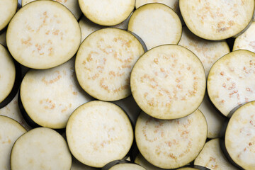 Slices of raw eggplant as background, top view