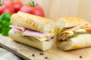 Sliced sandwich with ham, egg, cheese on a board