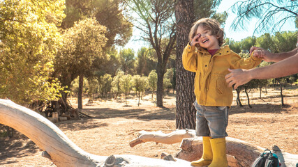 Young child is picking up plastic waste in the forest as a volunteer. Toddler and young children early environmental education concept.