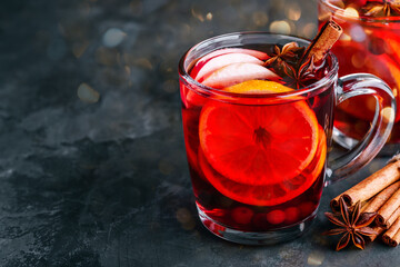 Christmas Mulled Wine with spices and fruits on a dark background, copy space.
