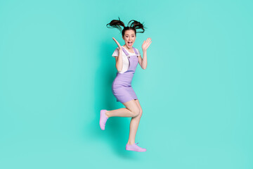 Full length photo of excited student lady jump raise palms open mouth wear violet mini overall sneakers isolated teal color background