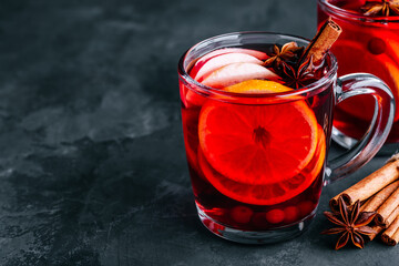 Christmas Mulled Wine with spices and fruits on a dark background, copy space.
