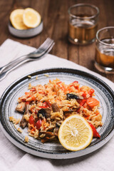Arroz con verduras y azafran, spanish dish. Vegetarian risotto with  vegetables, champignons and saffron on wooden table. Selective focus