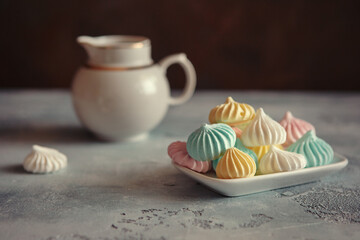 Meringues of a delicate pastel color are on the table for morning tea