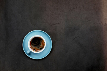 Blue coffee cup on dark background top view
