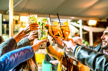 Group of happy friends drinking and toasting cocktail at bar - Friendship concept with young people...